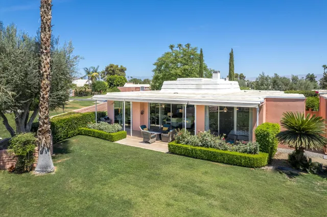 a view of a house with a yard and sitting area