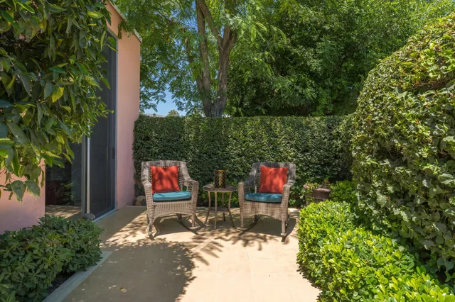 a view of a patio with dining table chairs and a yard