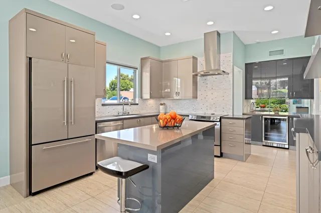 a kitchen with stainless steel appliances granite countertop a sink refrigerator and cabinets
