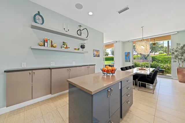 a view of a hallway with a dining table & chairs