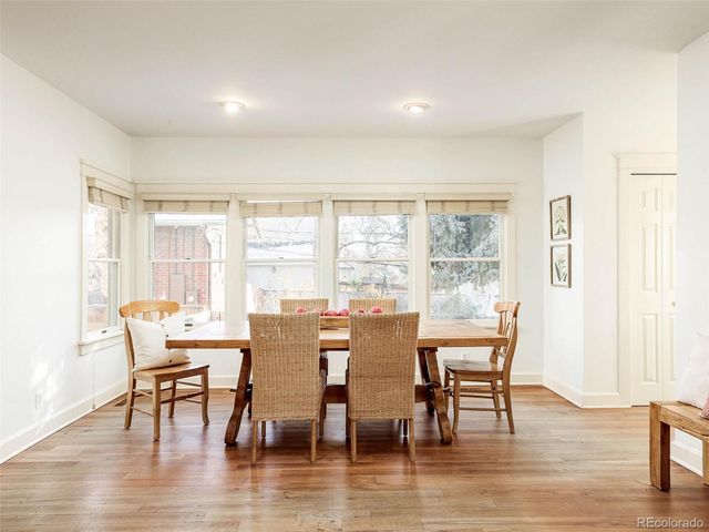 a dining room with furniture window and wooden floor