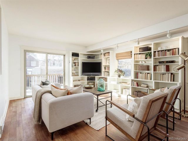 a living room with furniture a flat screen tv and a large window