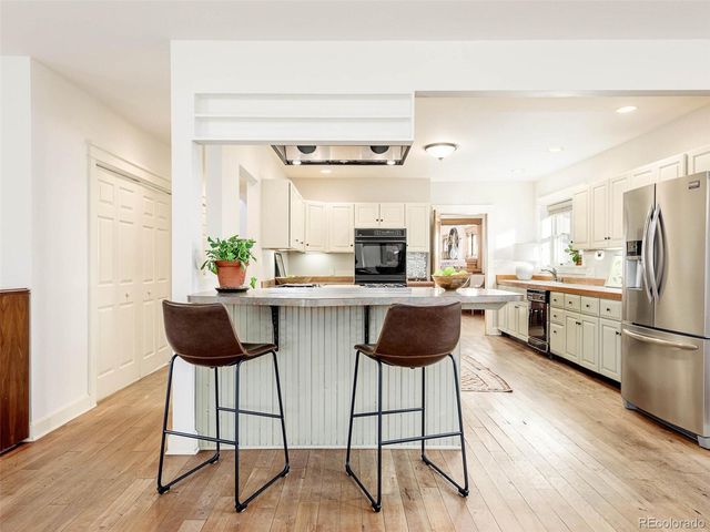 a kitchen with stainless steel appliances kitchen island granite countertop a refrigerator and a stove top oven