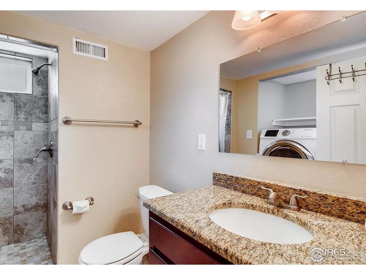 4870 Irving Street Denver, CO 80221 - Photo 14 of 19 a bathroom with a granite countertop sink a mirror and a toilet