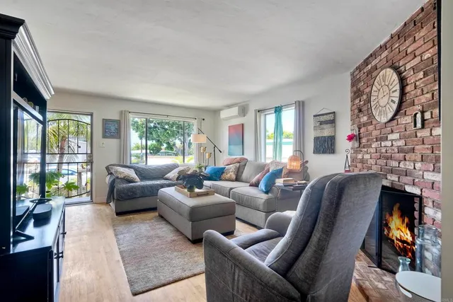 a living room with fireplace furniture and a large window