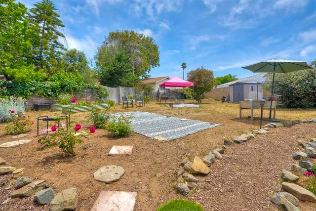 a view of a house with backyard and sitting area