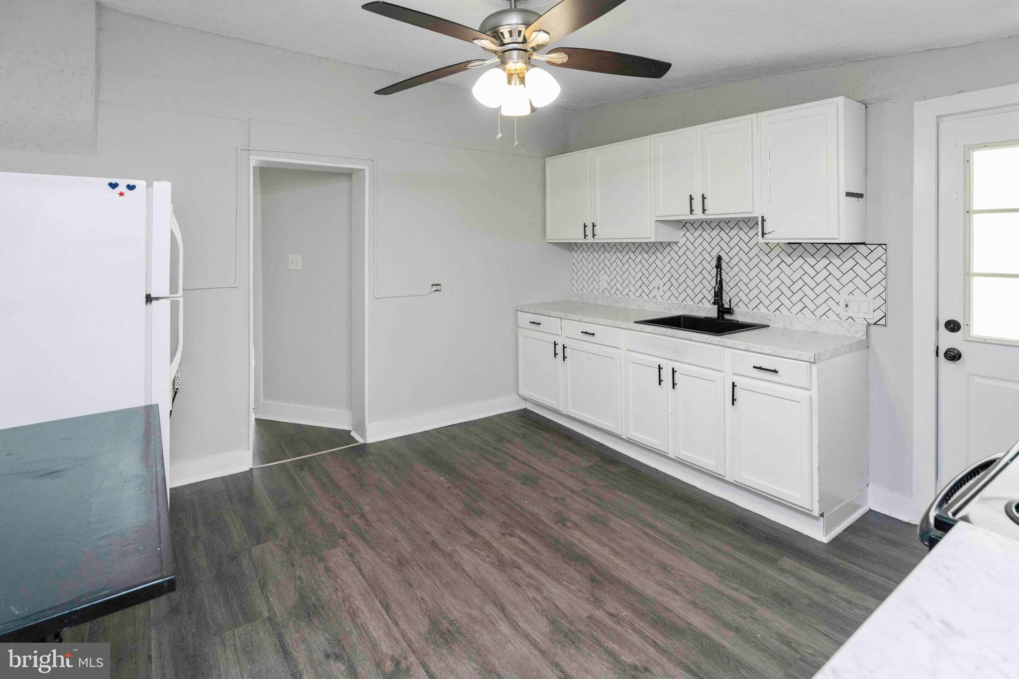 132 West Ridge Road Marcus Hook, PA 19061 - Photo 5 of 26 a kitchen with granite countertop a stove a sink and a refrigerator with wooden floors