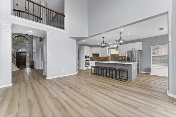 a kitchen with granite countertop a stove a sink a center island and wooden floor
