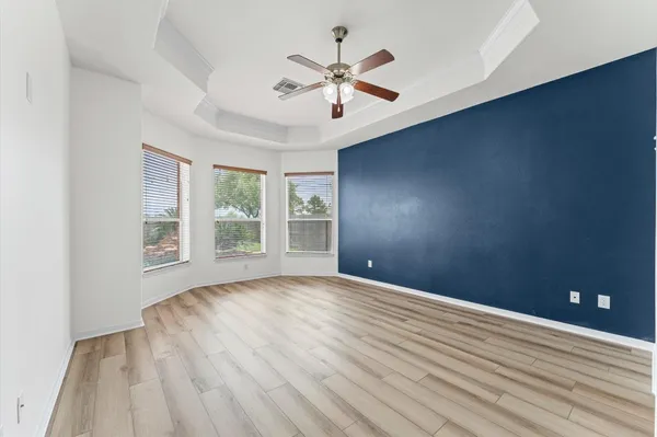 a view of a room with wooden floor chandelier and windows