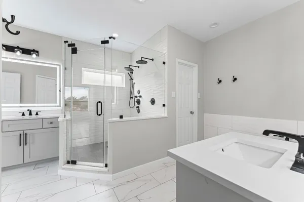 a bathroom with a sink a toilet and shower