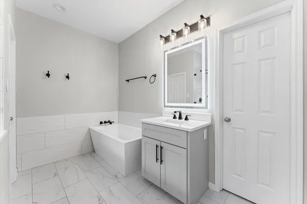 a spacious bathroom with a bathtub sink and mirror