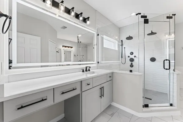 a bathroom with a shower sink and mirror