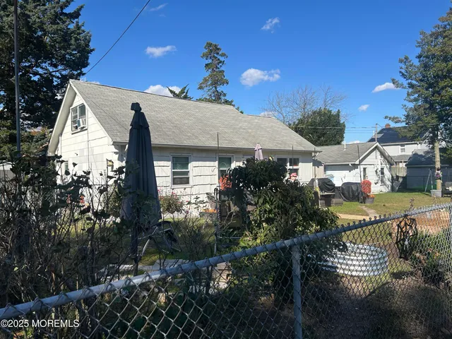 a view of house with yard and sitting area