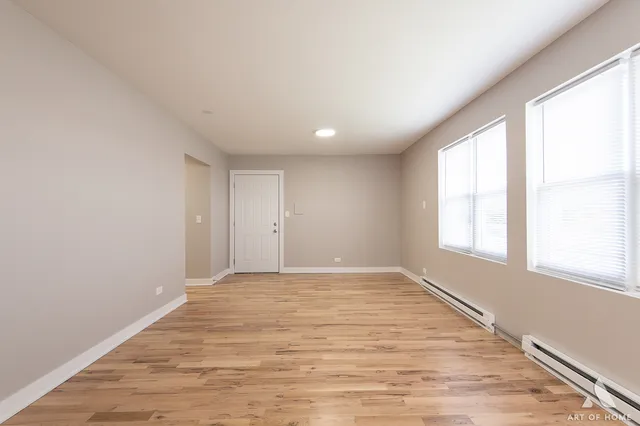an empty room with a window and a ceiling fan