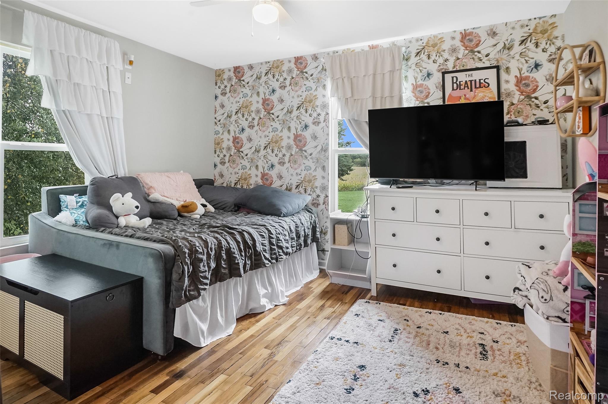 8330 Baldwin Road Gaines, MI 48436 - Photo 15 of 27 Wood-finish flooring with light-toned walls and a floral accent wall