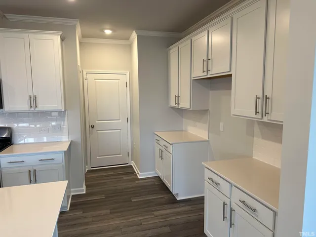 a kitchen with white cabinets and white appliances