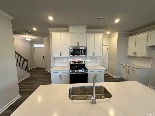 a kitchen with a sink and stainless steel appliances