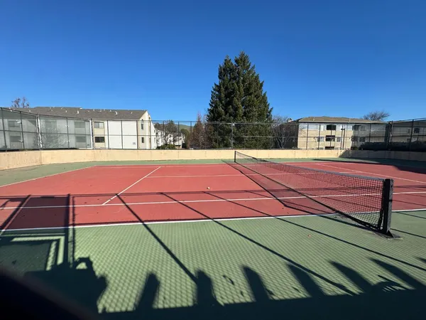 a tennis court with view of tall buildings