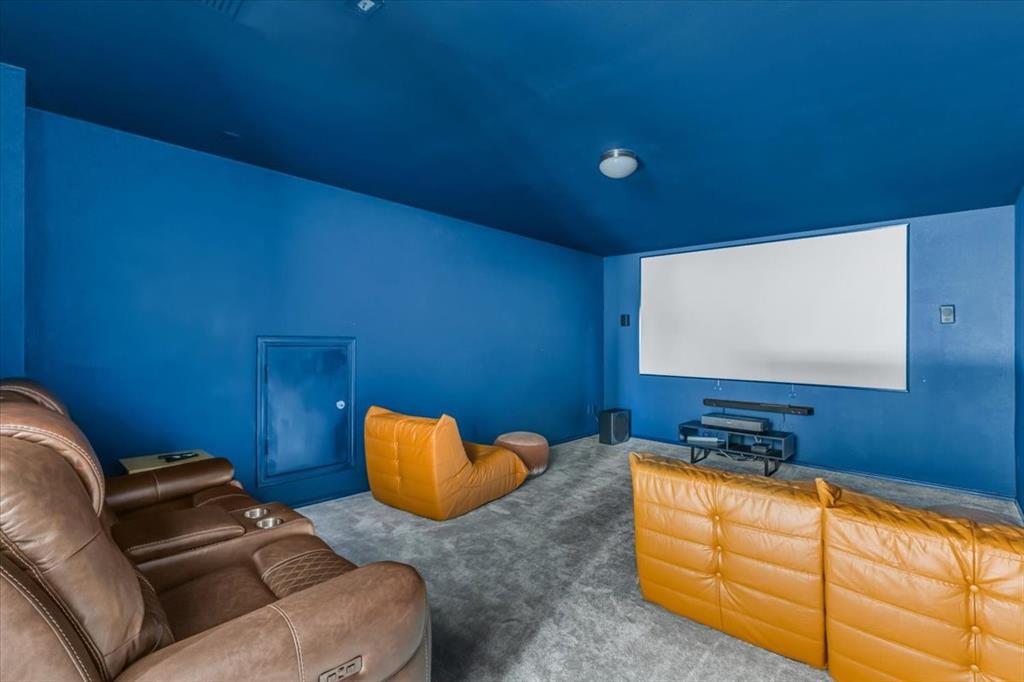 1201 Timberhurst Trail Fort Worth, TX 76131 - Photo 24 of 40 Dedicated media room with a large projection screen, dark blue walls, and grey carpeting