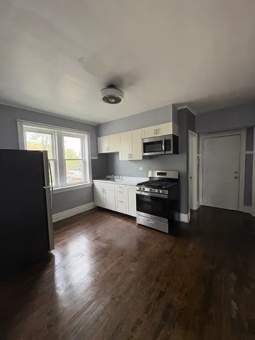a kitchen with granite countertop a refrigerator and a stove top oven