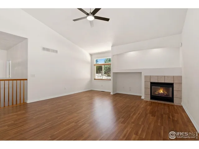 a view of an empty room with a fireplace and a window