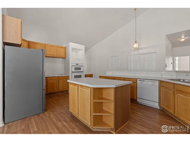 a kitchen with kitchen island a counter top space a sink stainless steel appliances and cabinets