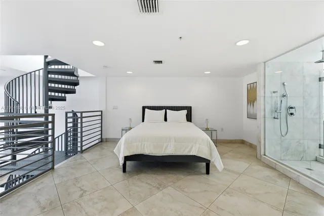 a spacious bedroom with a bed and a chandelier