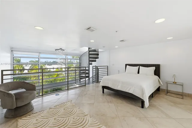 a spacious bedroom with a bed and large window