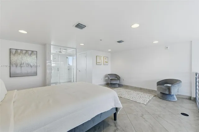 a spacious bedroom with a bed and a painting