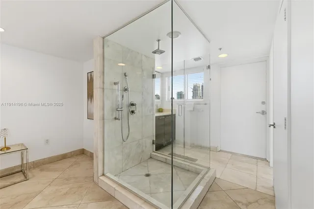 a bathroom with a glass shower door and a glass door