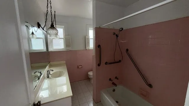 a bathroom with a tub sink and mirror