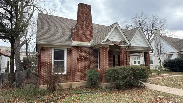 a front view of a house with a yard and potted plants