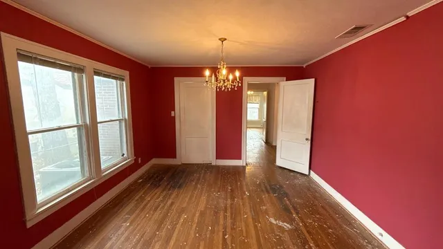 a view of a room with window wooden floor and chandelier
