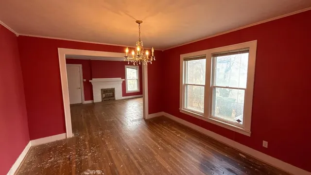 a view of a room with wooden floor fireplace and a window