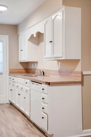 a kitchen with granite countertop white cabinets and sink