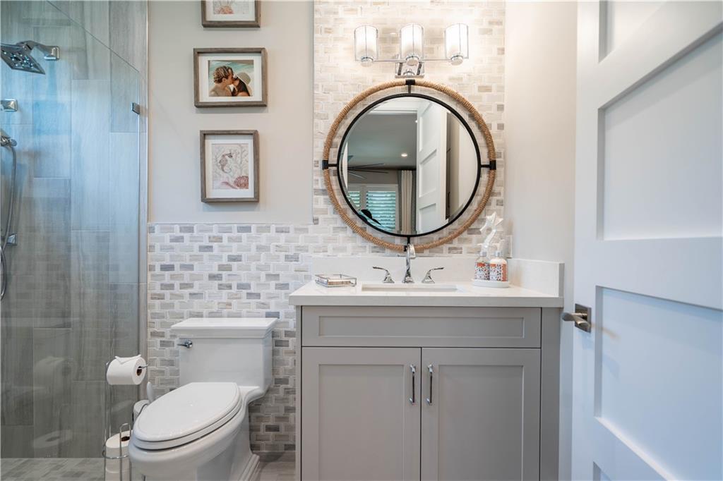 2349 Northeast 24th Street Lighthouse Point, FL 33064 - Photo 58 of 85 a bathroom with a toilet a sink and mirror