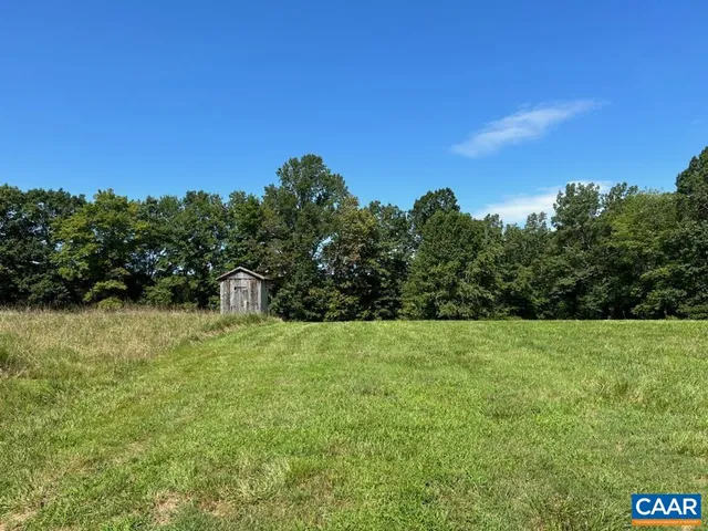 a view of grassy field with trees in the background