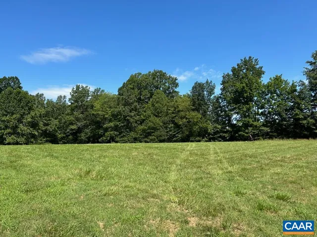 a view of grassy field with trees in the background