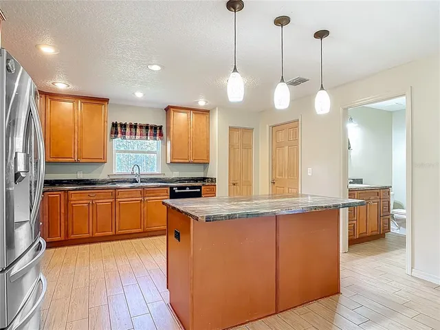 a bathroom with a granite countertop sink mirror vanity and toilet