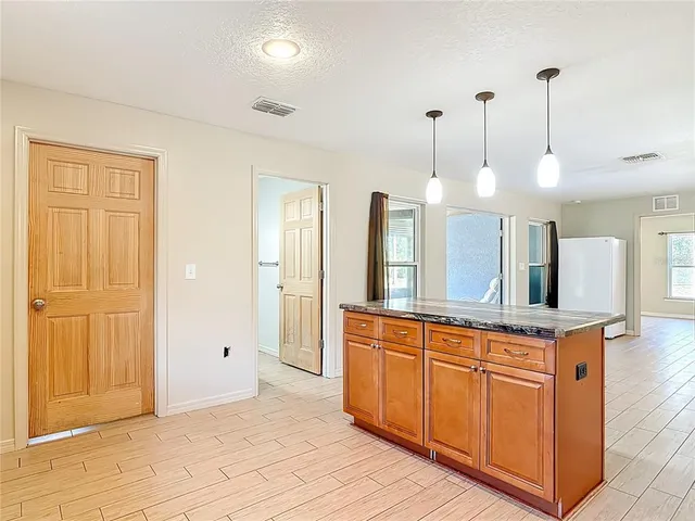 an empty room with wooden floor and ceiling fan