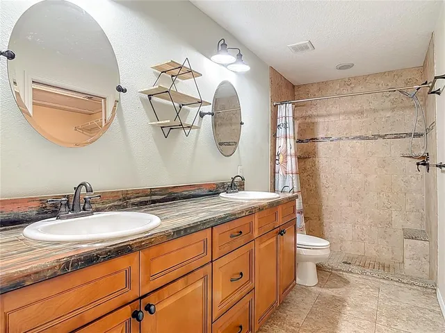 a bathroom with a granite countertop toilet sink and vanity