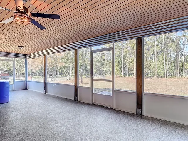 a view of a yard with a table and chair under an umbrella