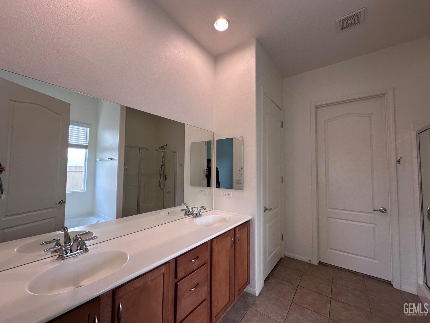 Undisclosed Address Bakersfield, CA 93306 - Photo 39 of 43 a bathroom with a double vanity sink and mirror