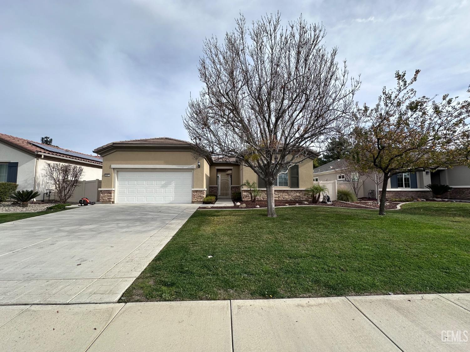 Undisclosed Address Bakersfield, CA 93306 - Photo 5 of 43 a front view of a house with a yard and garage