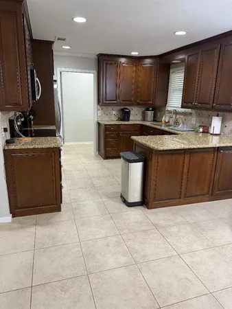 a kitchen with stainless steel appliances granite countertop a stove a sink and a microwave