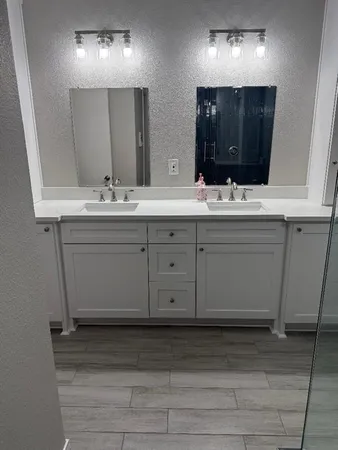 a bathroom with double sink and a mirror