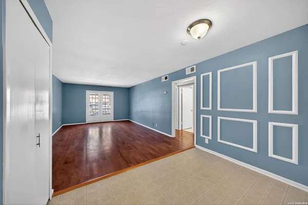 a view of an empty room with stairs and chandelier fan