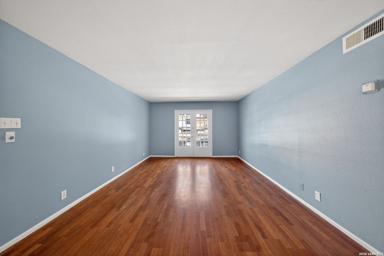 6718 Callaghan Road, Unit 315 San Antonio, TX 78229 - Photo 17 of 27 a view of an empty room with wooden floor and a window
