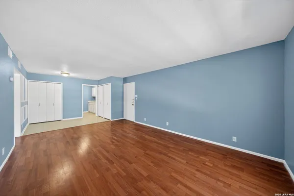 a view of empty room with wooden floor