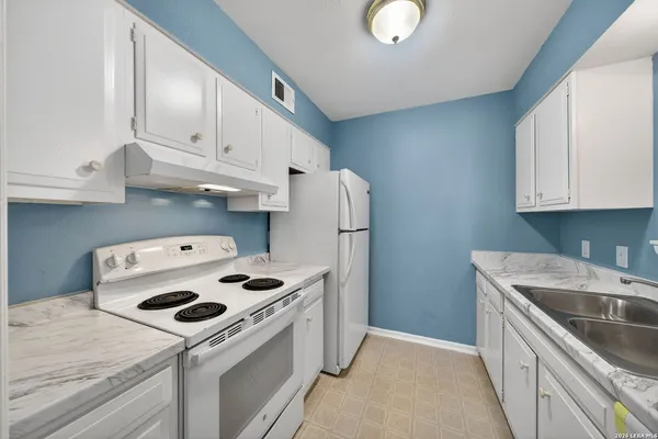 a kitchen with kitchen island a white stove top oven and refrigerator